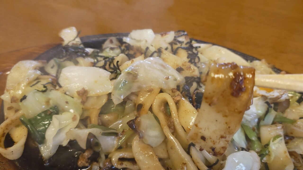 びしゃもんの焼うどんの幅広い麺と野菜を箸で持ち上げた様子