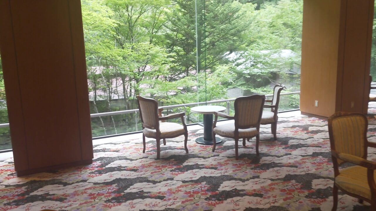 大きな窓から緑を眺められるホテル湯西川のロビー
