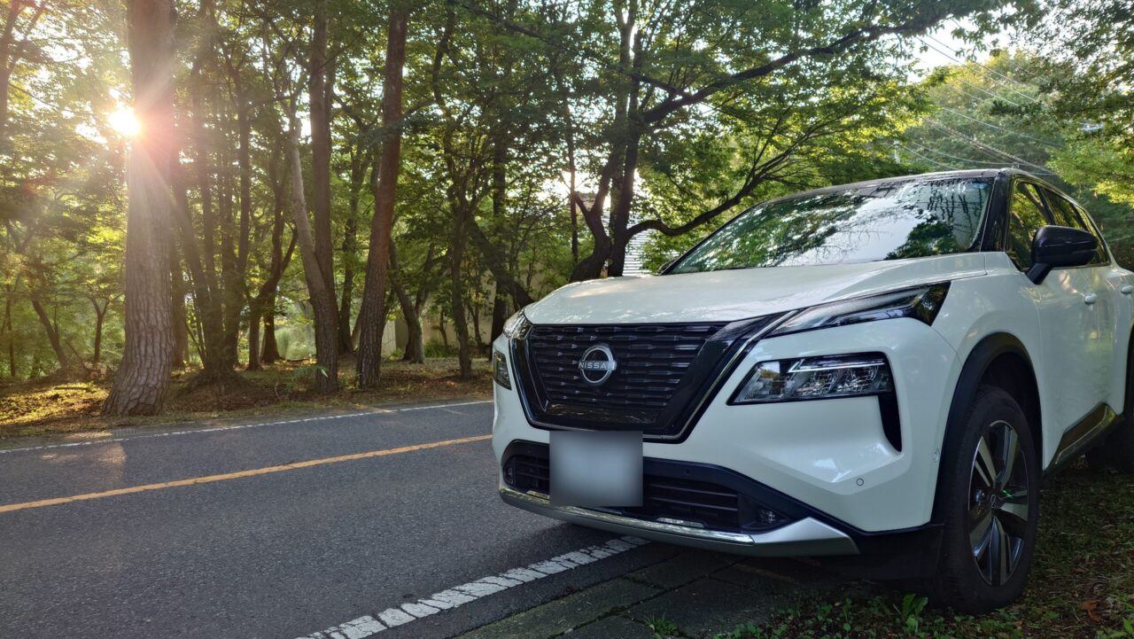 朝日が差し込む那須高原の木漏れ日の中を走る白い日産エクストレイルT33
